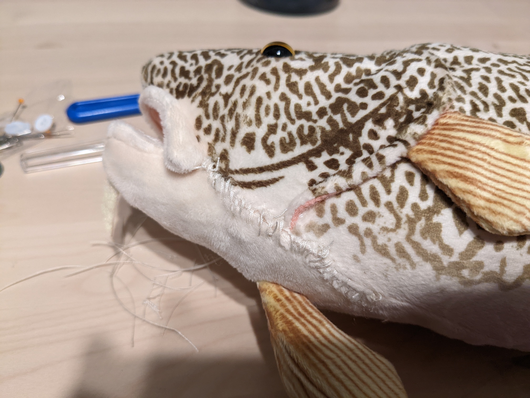 a plush codfish with a rough seam on it